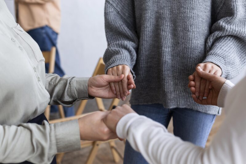 people-holding-hands-group-therapy-session